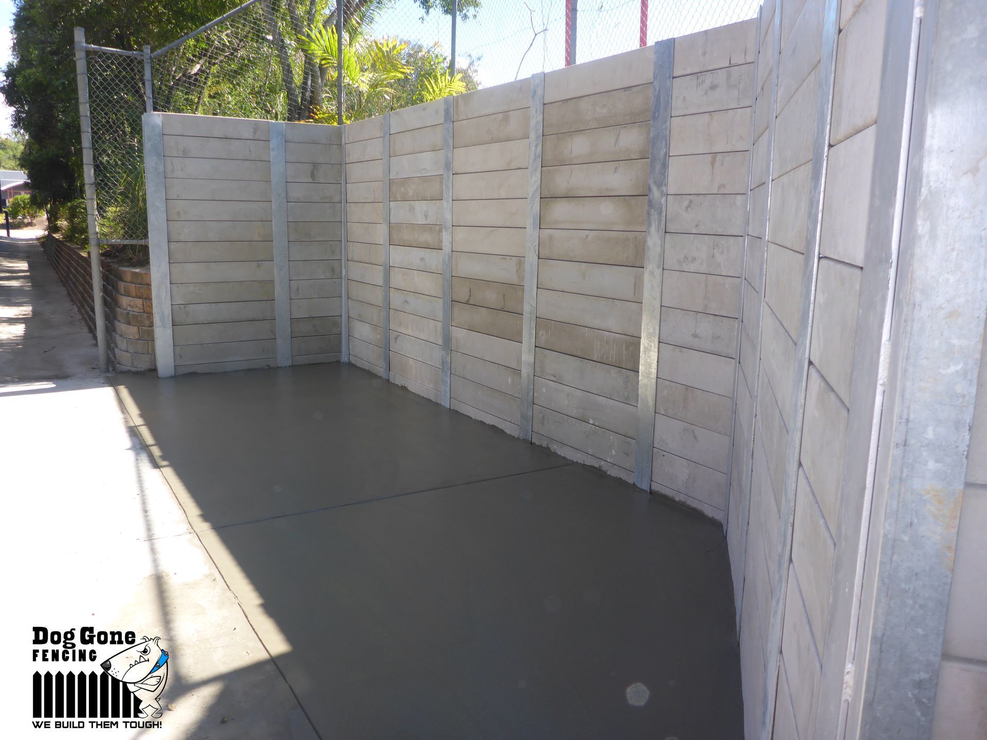 A Concrete Wall With A Dog Care Logo On The Bottom — Dog Gone Fencing in Paget, QLD