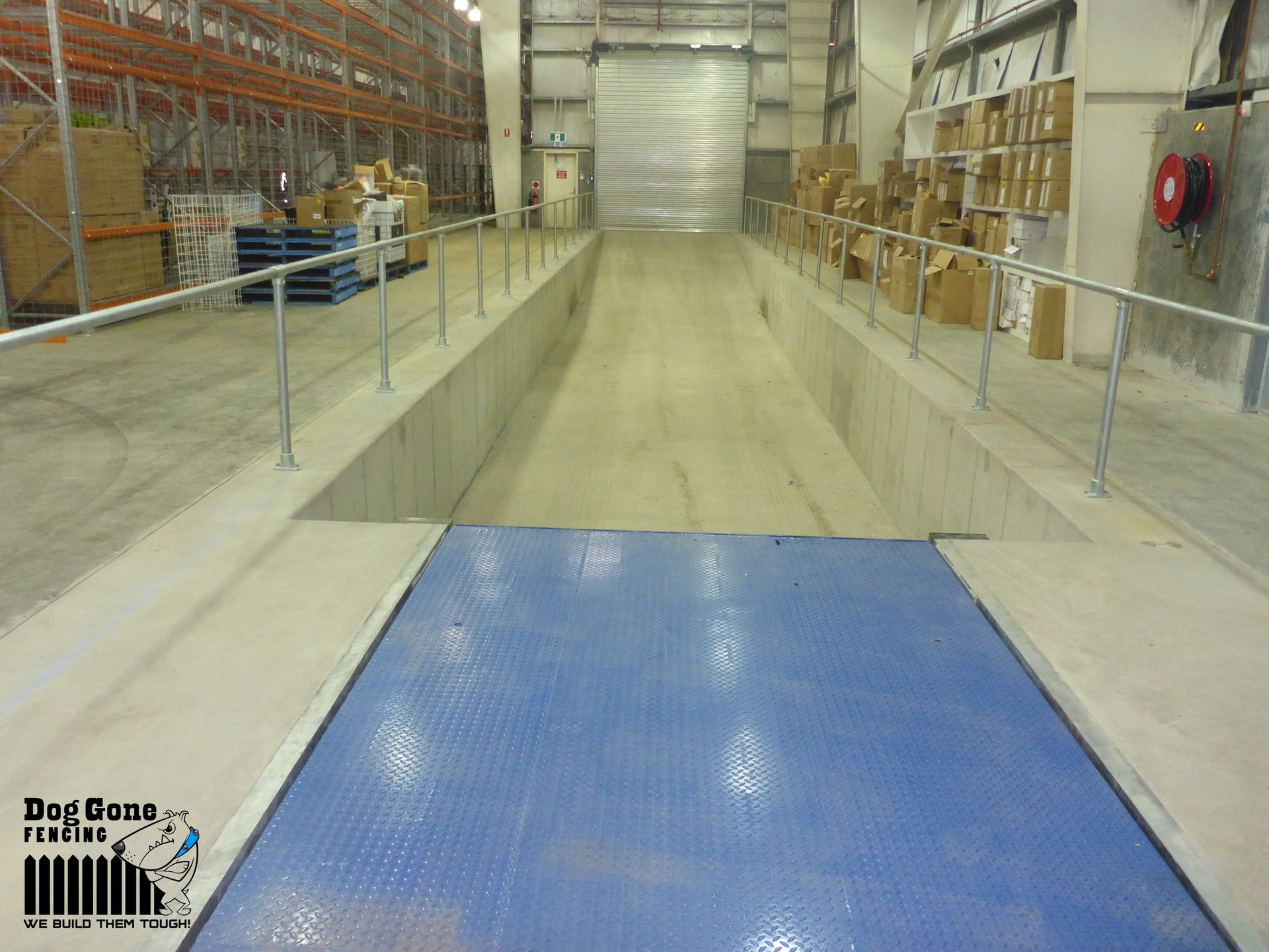 A Large Warehouse With A Blue Scale In The Middle — Dog Gone Fencing in Paget, QLD
