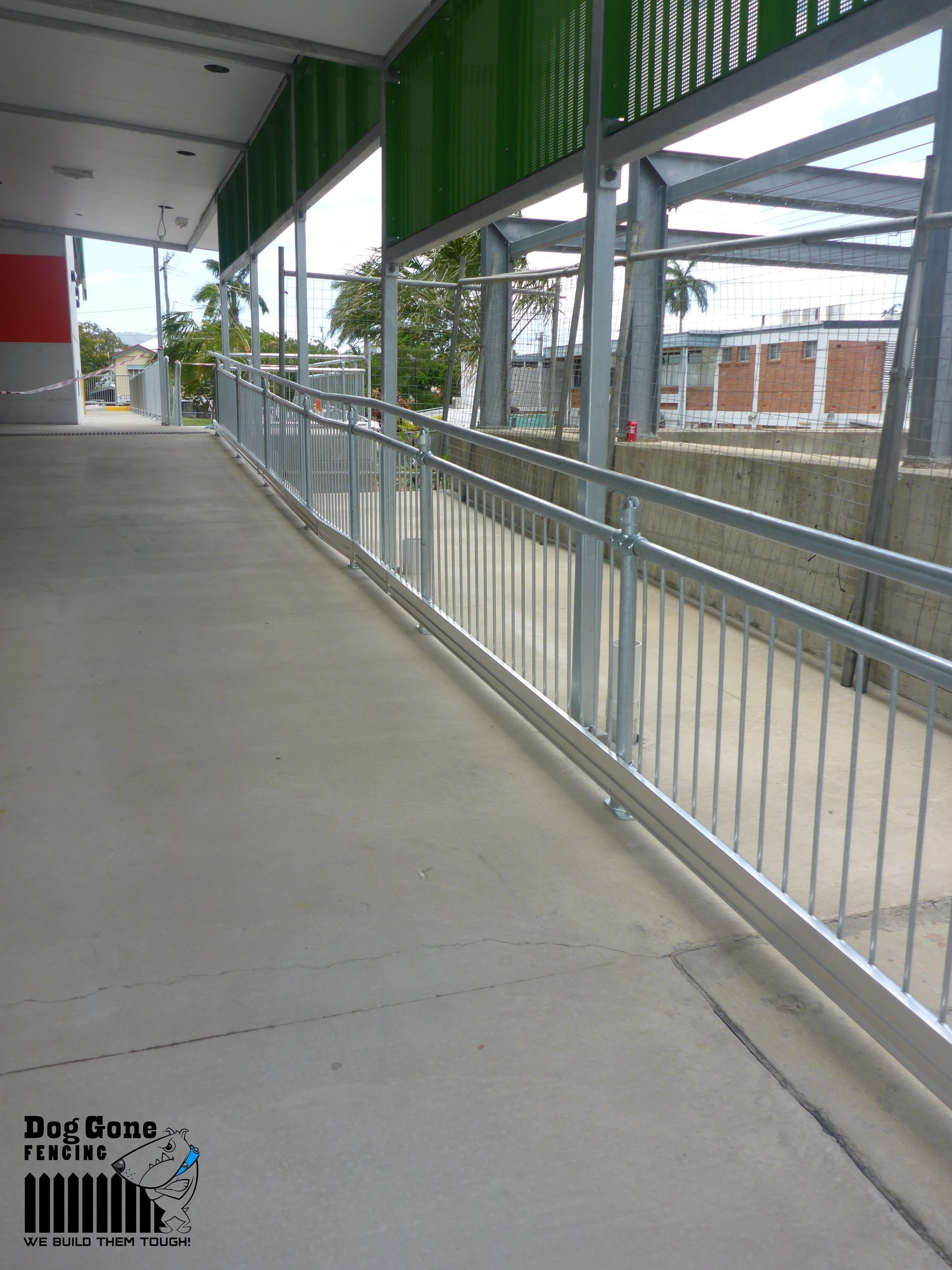 A Concrete Walkway With A Metal Railing Along The Side Of It — Dog Gone Fencing in Paget, QLD