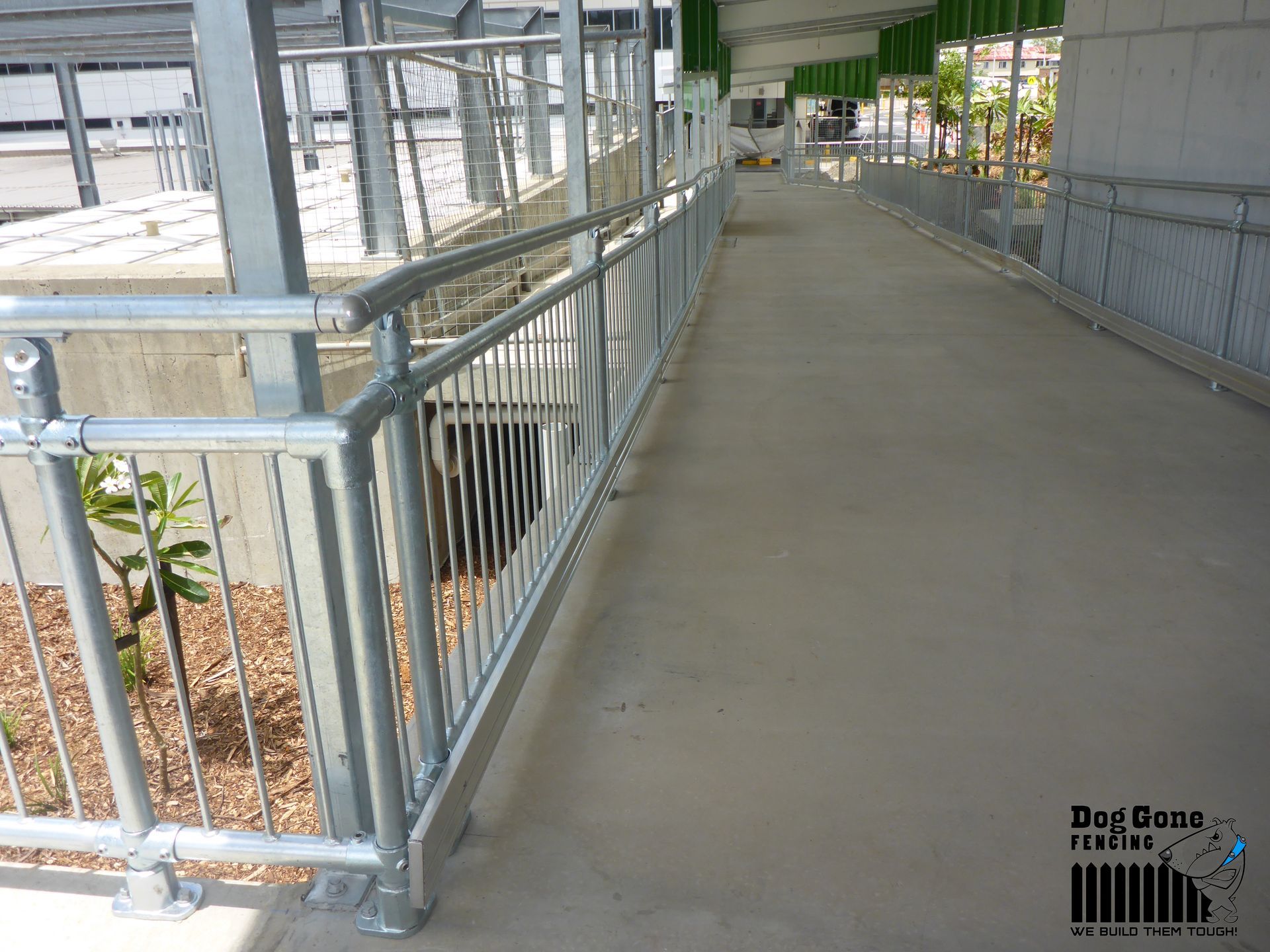 A Walkway With A Metal Railing And A Sign That Says Day Care — Dog Gone Fencing in Paget, QLD