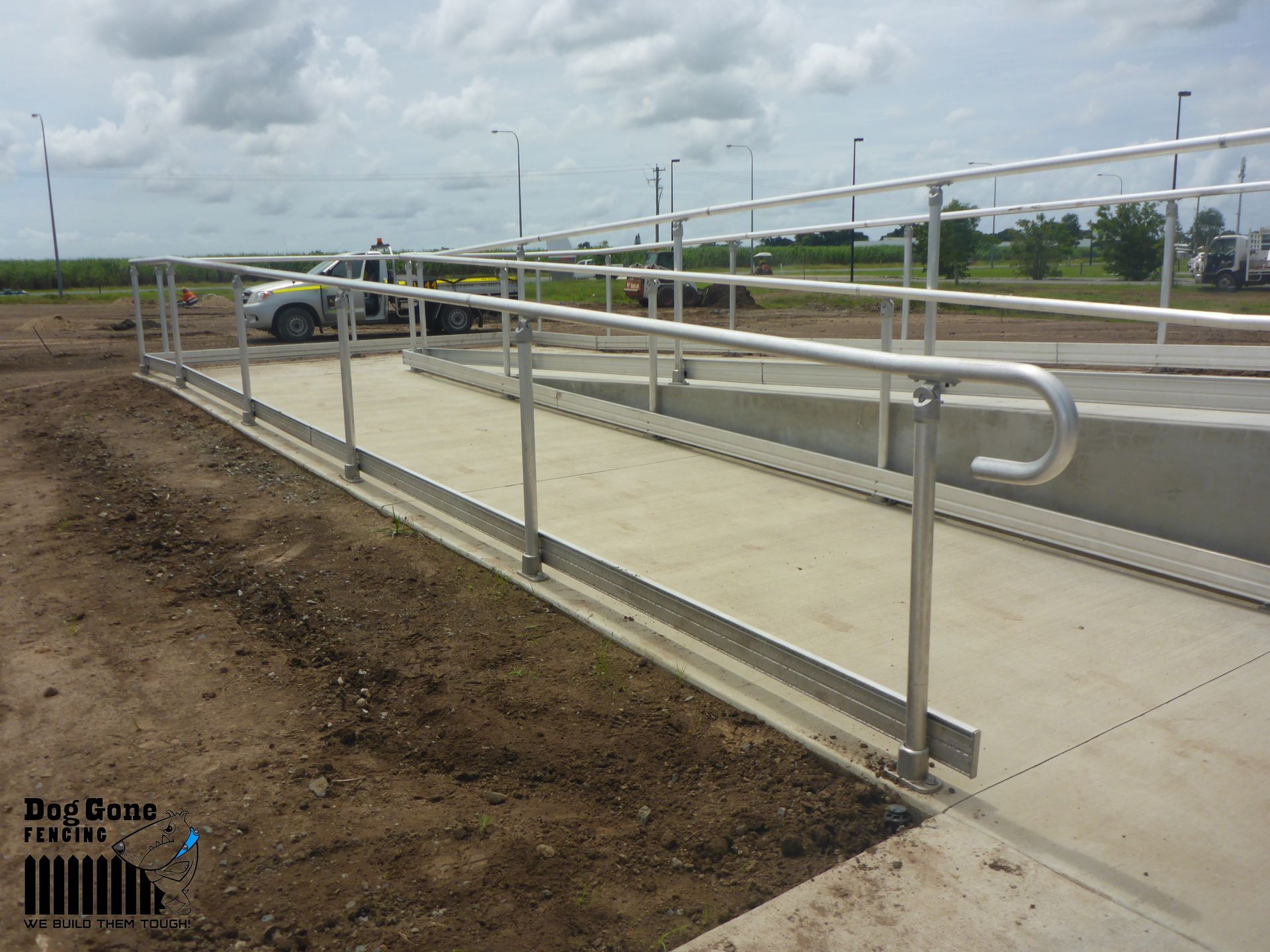 A Ramp With A Stainless Steel Railing And A Truck In The Background — Dog Gone Fencing in Paget, QLD