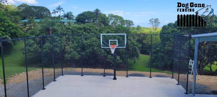 A Basketball Hoop Is Surrounded By A Fence In A Backyard — Dog Gone Fencing in Paget, QLD