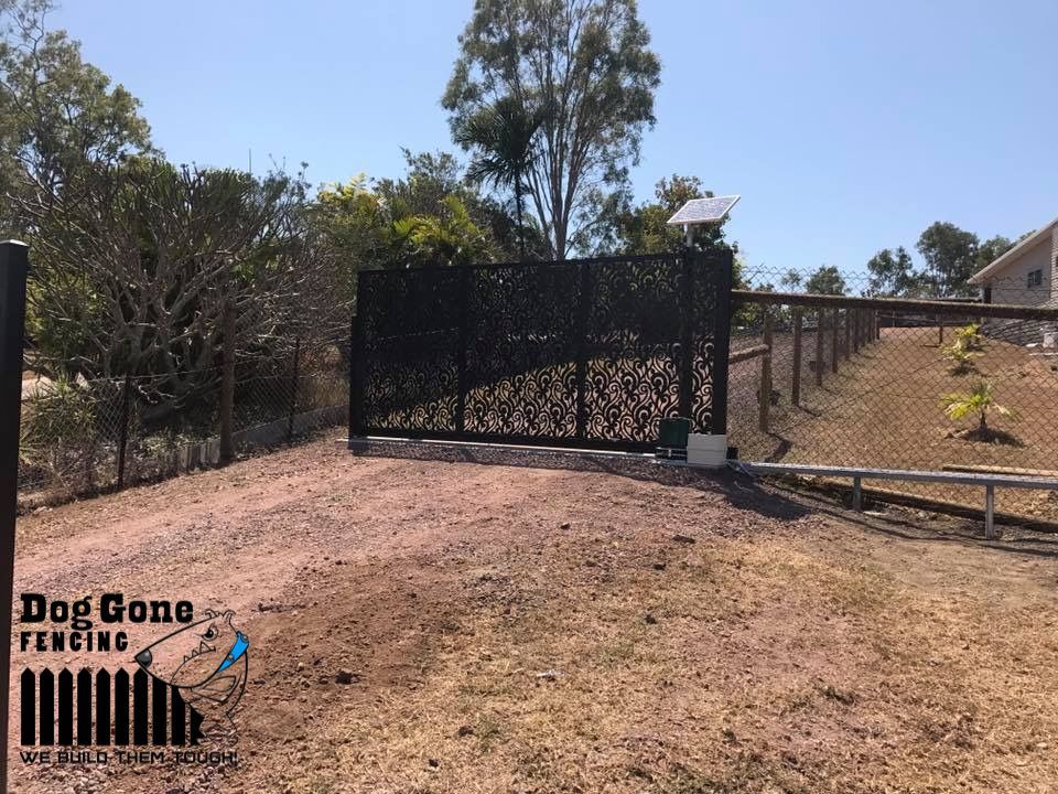 A Black Gate Is Sitting In The Middle Of A Dirt Road — Dog Gone Fencing in Paget, QLD