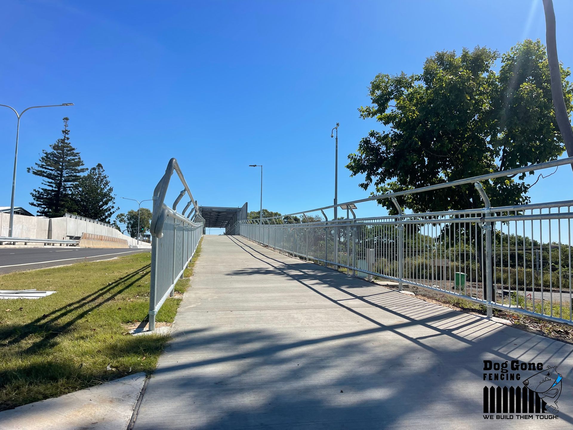 A Concrete Walkway With A Metal Fence Along The Side Of It — Dog Gone Fencing in Paget, QLD