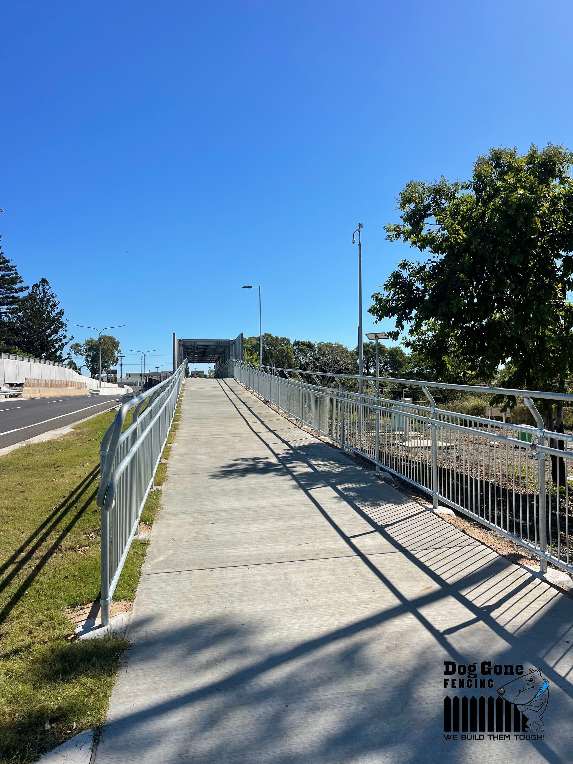 A Concrete Walkway with a metal railing leading to a bridge - Fencing in Mackay, QLD