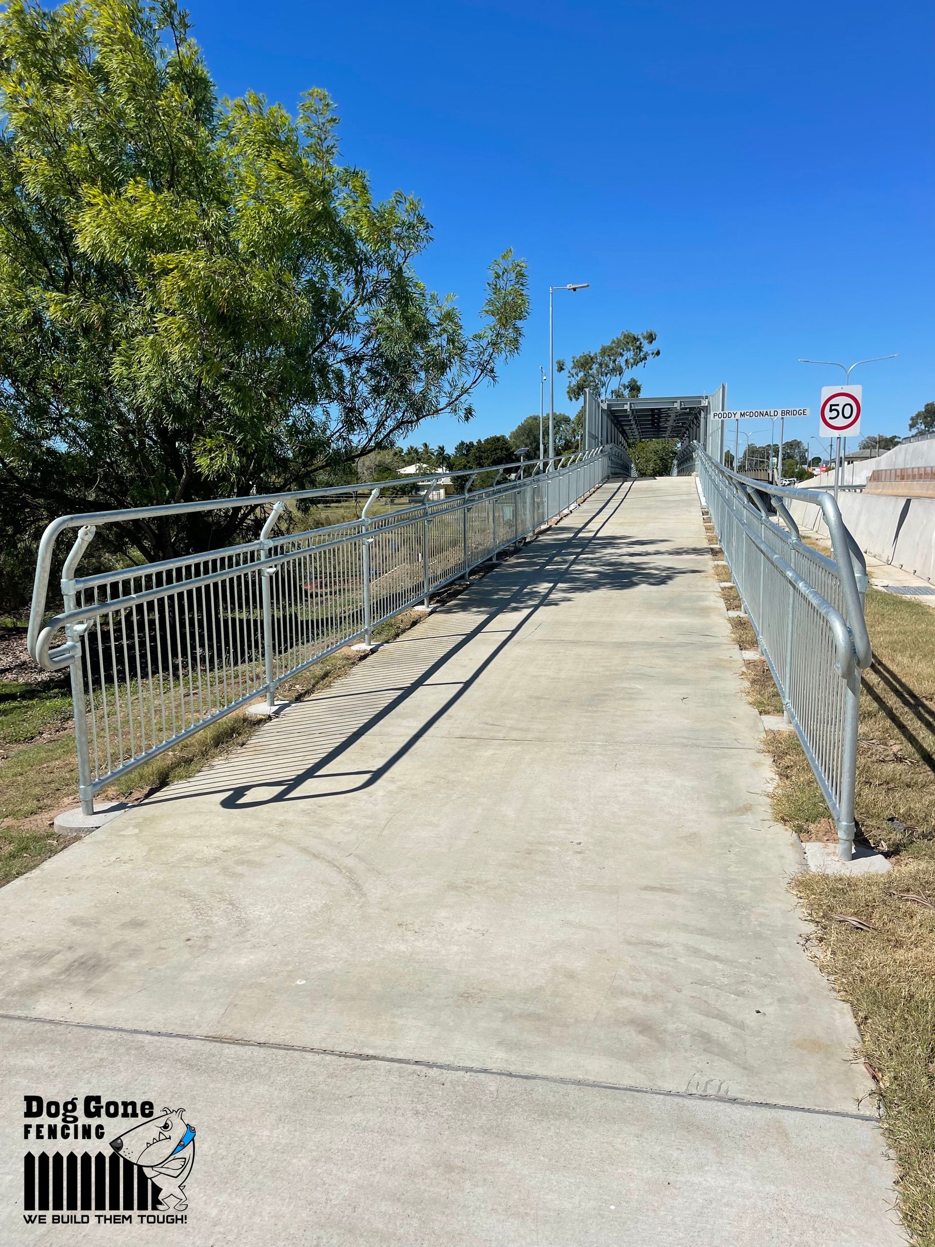 A Concrete Walkway With A Metal Fence Along The Side Of It — Dog Gone Fencing in Paget, QLD
