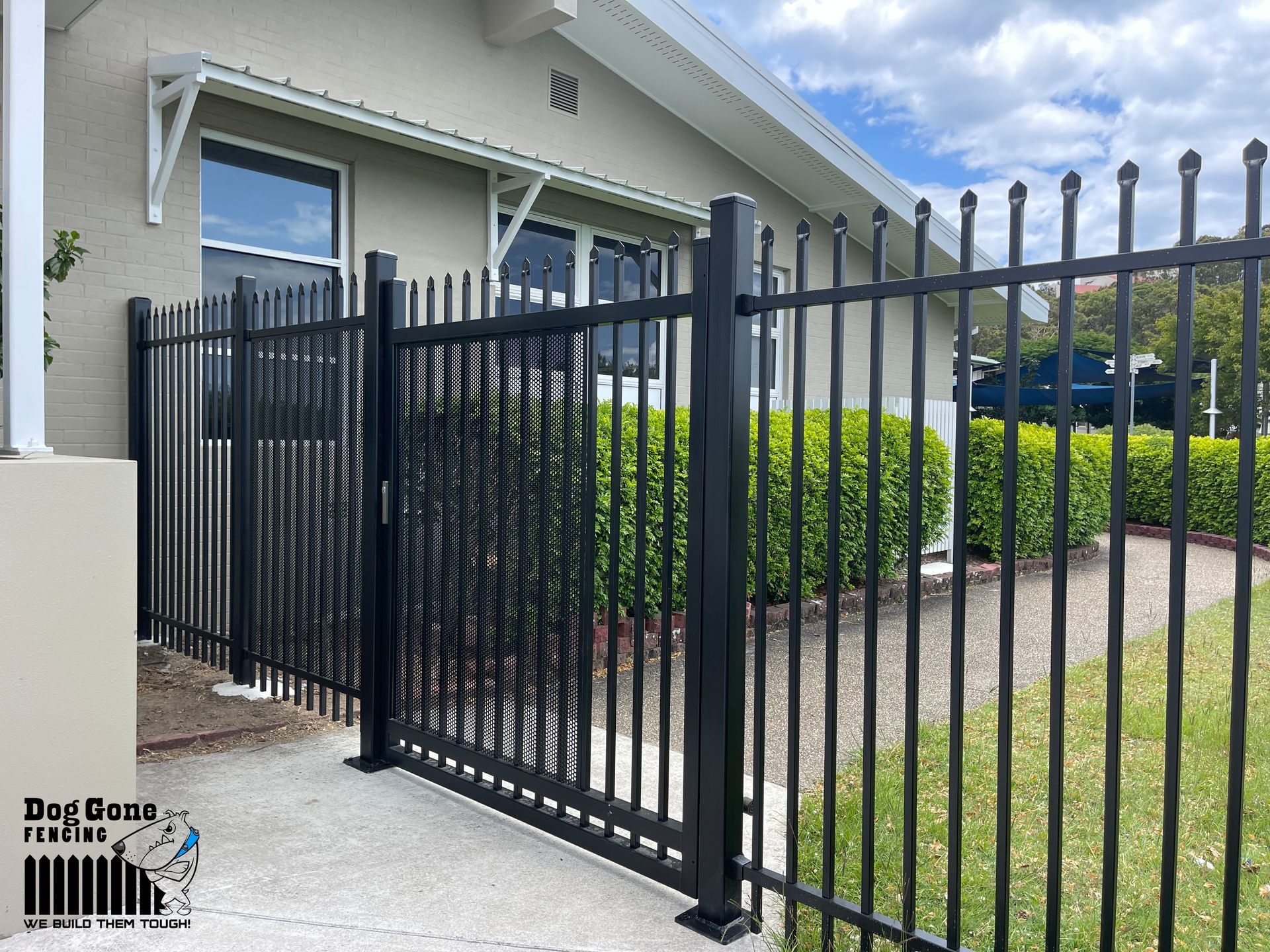 A Black Metal Fence Is In Front Of A House — Dog Gone Fencing in Paget, QLD