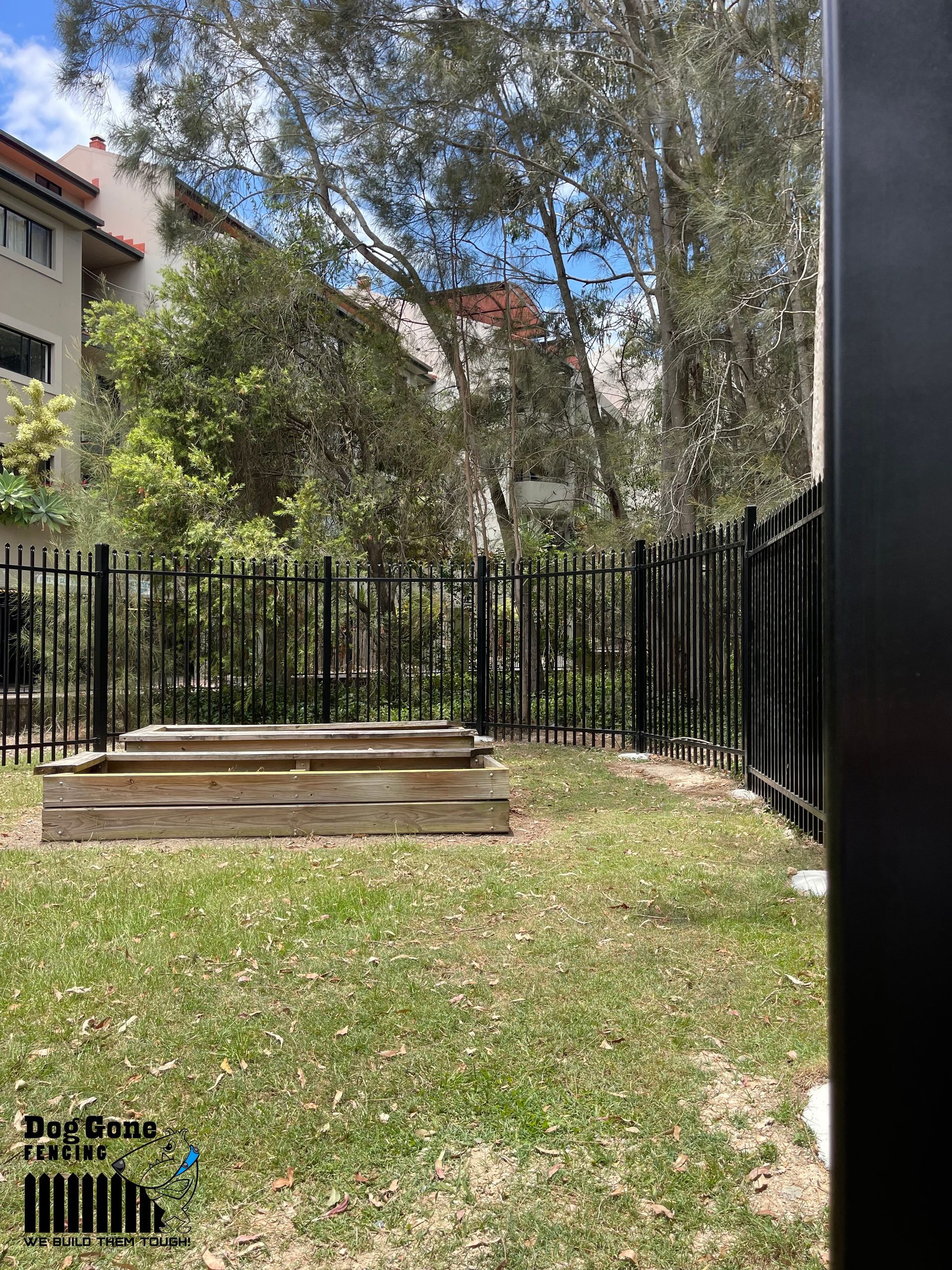 A Backyard With A Fence And A Wooden Box In The Middle Of It — Dog Gone Fencing in Paget, QLD