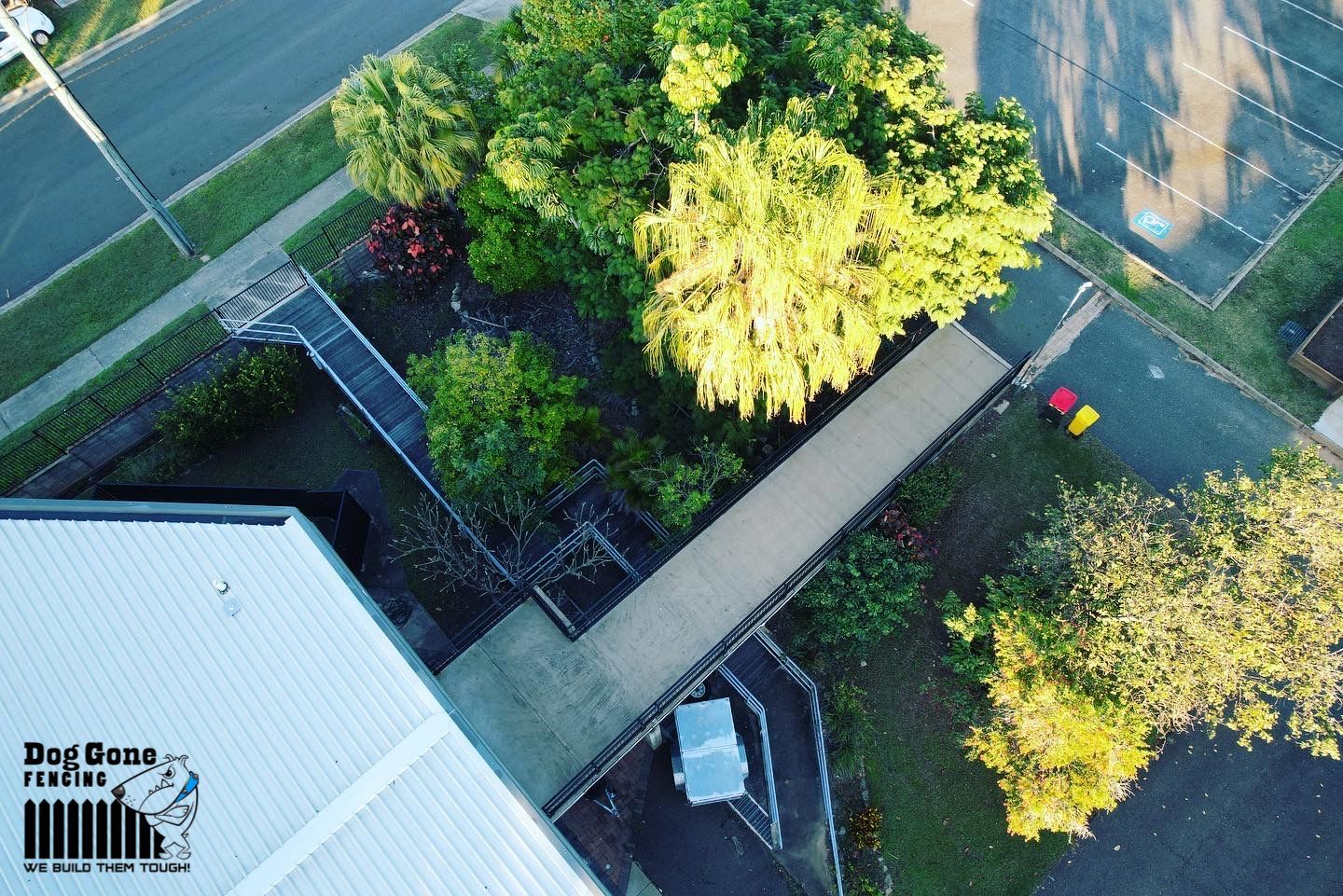 An Aerial View Of A Residential Area With A Building And Trees — Dog Gone Fencing in Paget, QLD