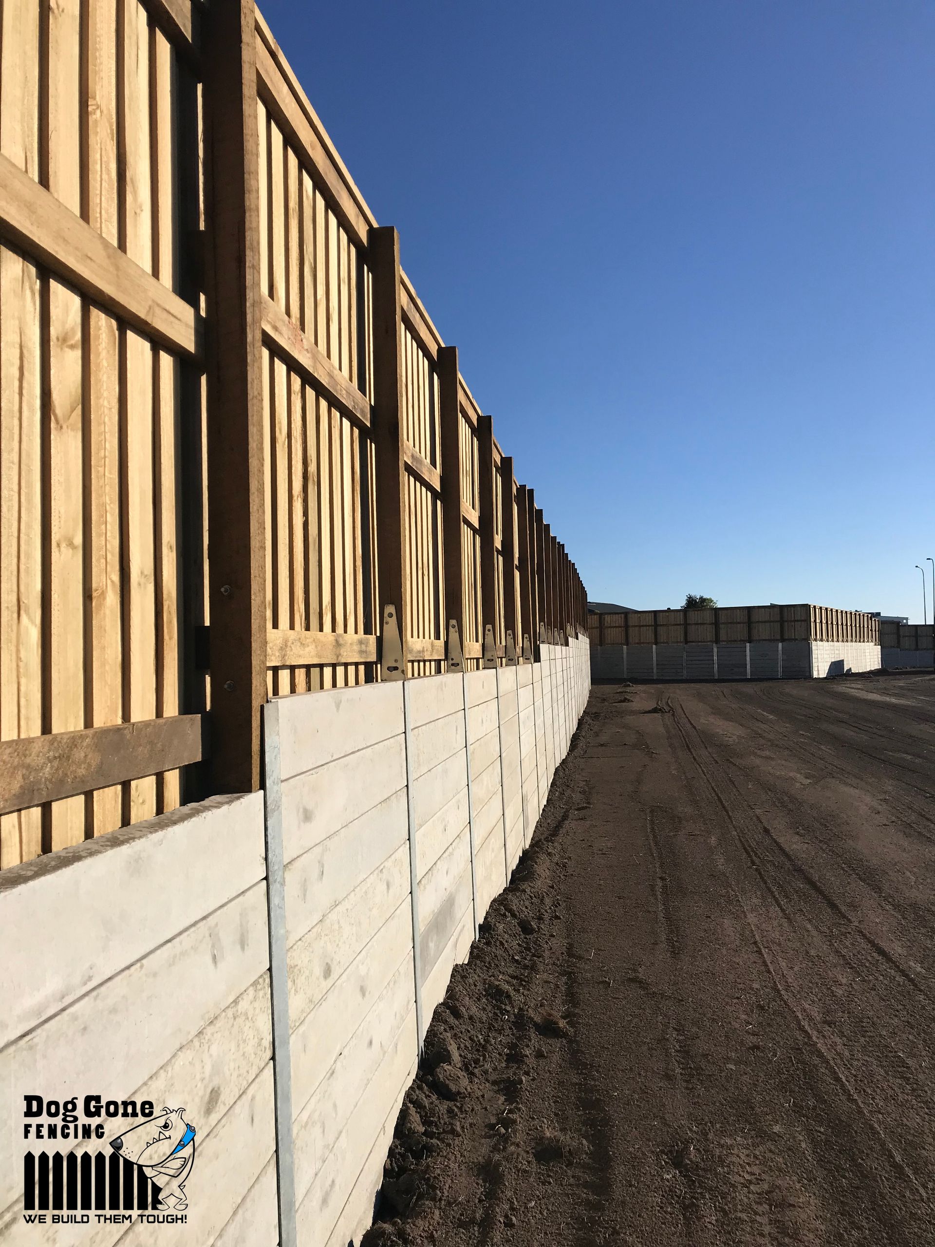A Wooden Fence Is Surrounding A Dirt Road — Dog Gone Fencing in Paget, QLD