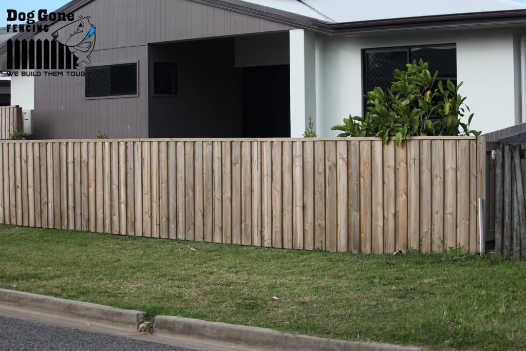 A House With A Wooden Fence In Front Of It — Dog Gone Fencing in Paget, QLD