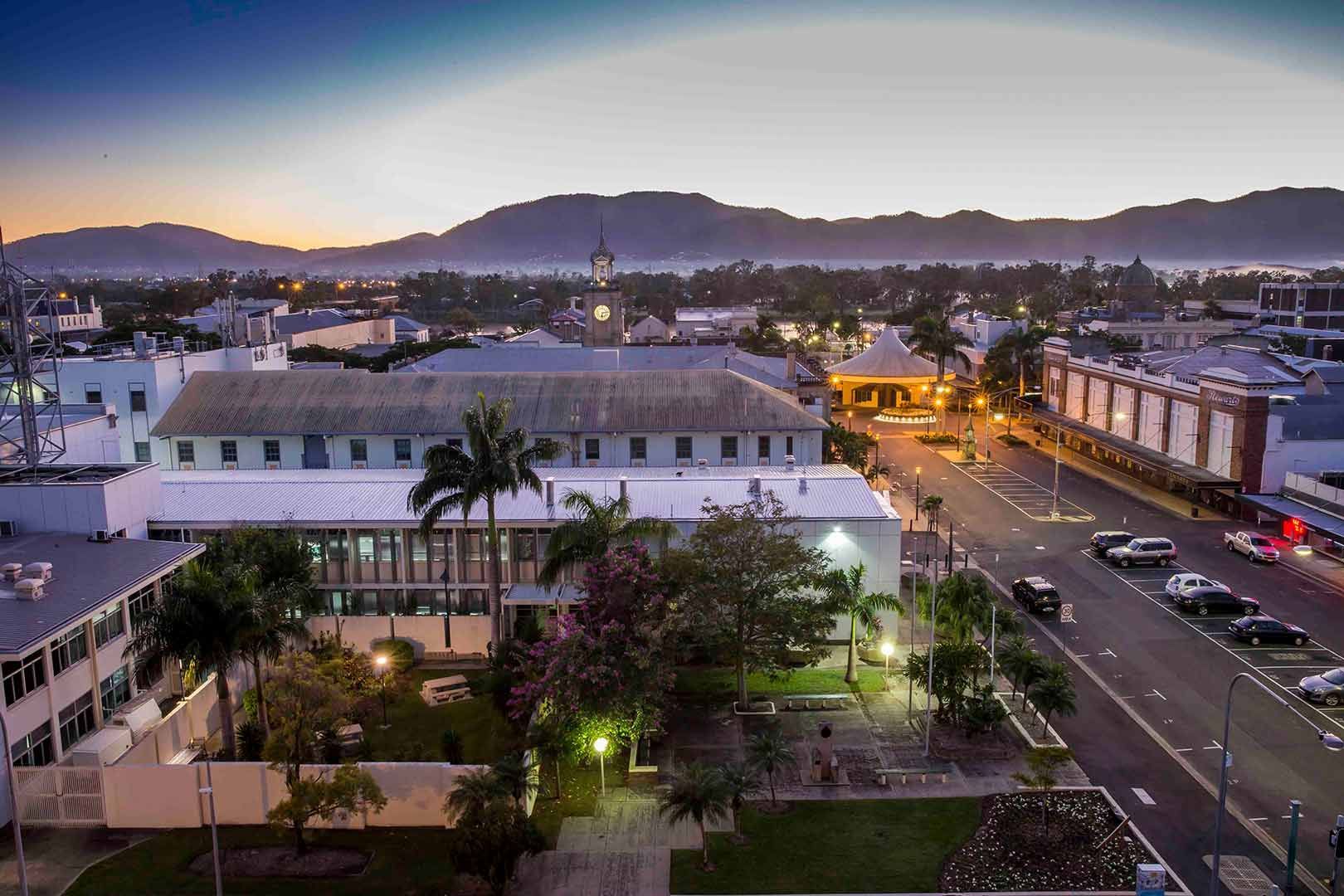 An Aerial View Of A City At Night With Mountains In The Background — Dog Gone Fencing in Rockhampton, QLD
