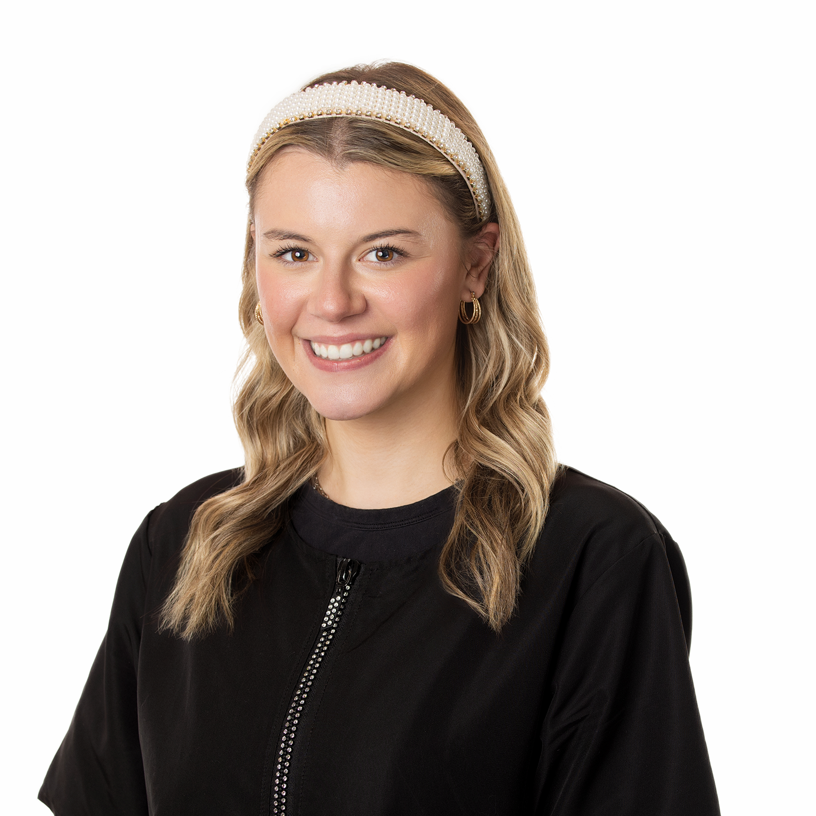 The woman is wearing a headband and smiling for the camera.