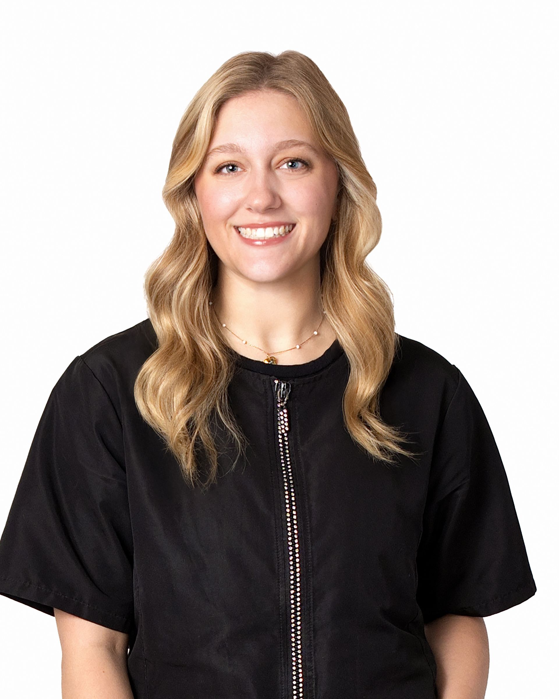 A woman with blonde hair is wearing a black jacket and smiling