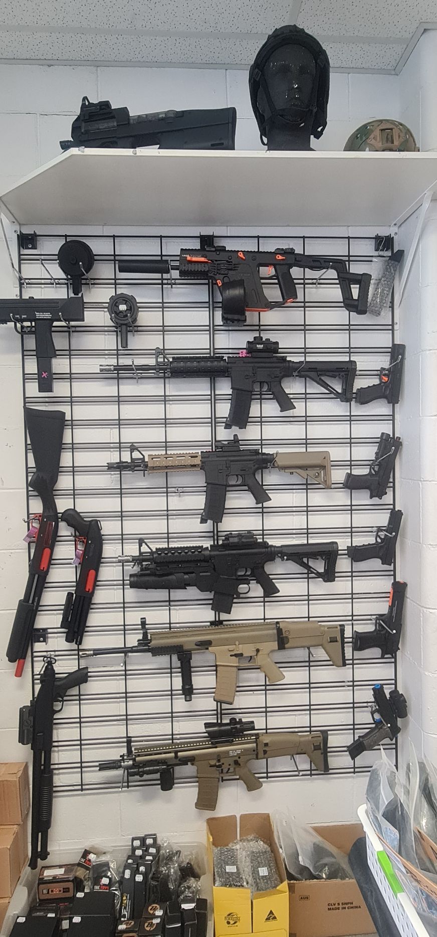 Guns and Accessories Displayed on a Wire Grid Shelf in a Store Setting — Central Western Communications in Emerald, QLD