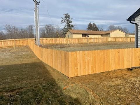 A wooden fence is in the backyard of a house. | Winfield, MO | Americas fence & Deck Company
