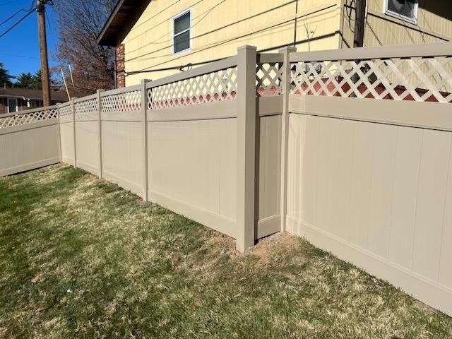 A white fence with a lattice design is in front of a house  | Ellisville, MO | Americas fence & Deck