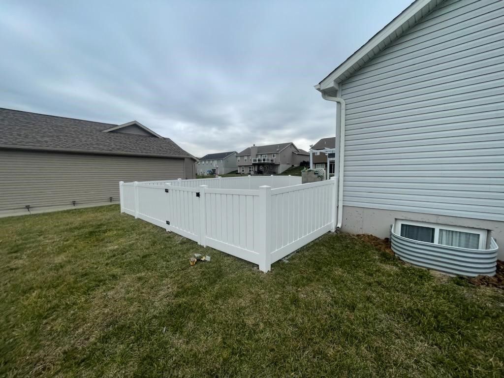 A white fence is in the backyard of a house. | O'Fallon, MO | Americas fence & Deck Company
