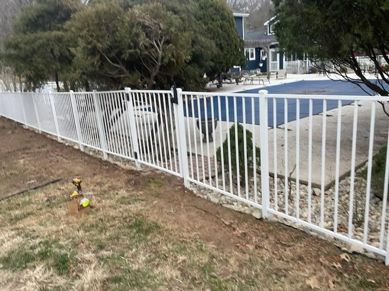A white fence is being built in front of a house. | Ellisville, MO | Americas fence & Deck Company
