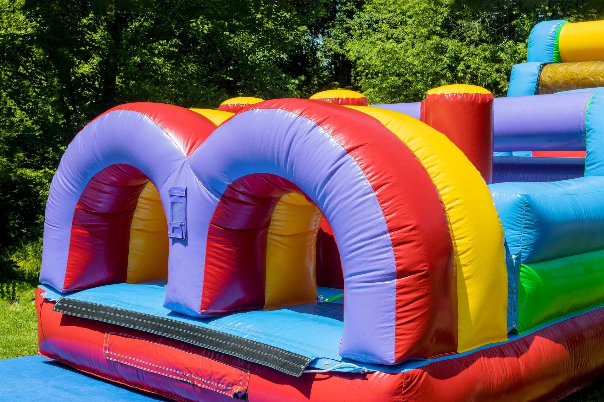 Rental party inflatables featuring a colorful obstacle course setup in an outdoor area, ideal for fe