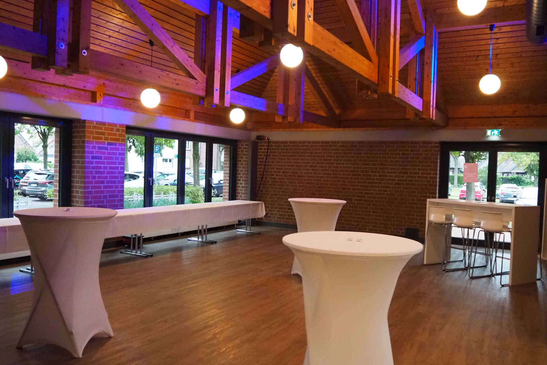 Ein Raum mit Tischen und Stühlen und einer Ziegelwand.