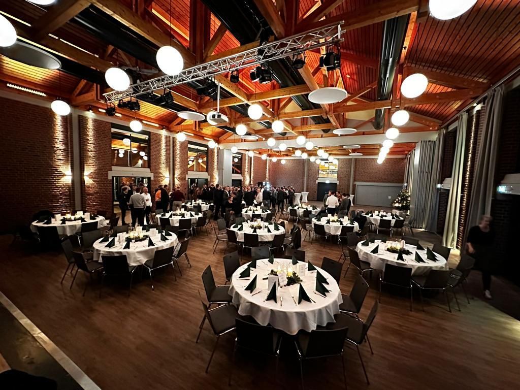 Ein großer Raum mit Tischen und Stühlen, die für eine Party aufgestellt sind.