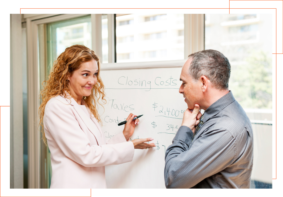 A man and a woman are standing in front of a whiteboard.
