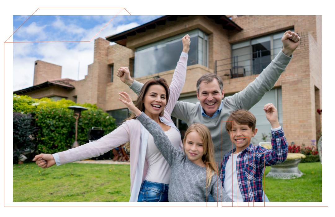 A family is standing in front of a house with their arms in the air.