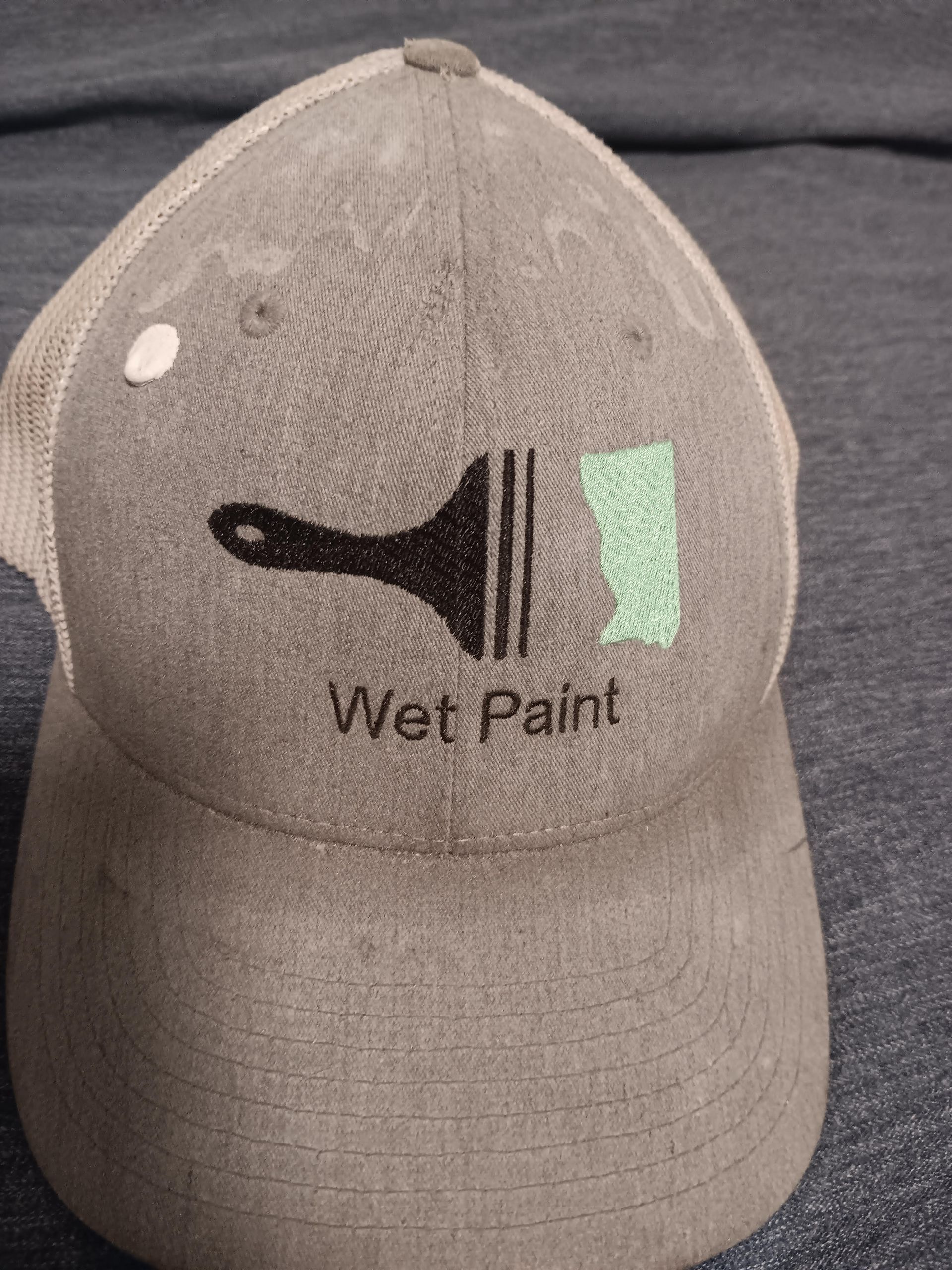 Gray cap with a paint brush logo. Text reads