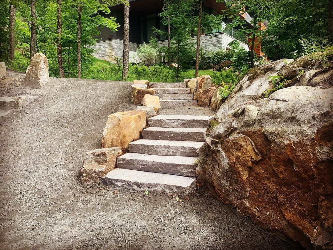 Un escalier en pierre menant à une maison dans les bois.