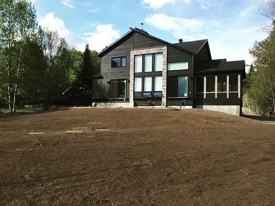 Une grande maison avec beaucoup de terre devant