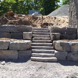 Un mur de pierre avec des escaliers qui y mènent est en cours de construction.