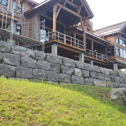 Une grande maison est en cours de construction au sommet d'une paroi rocheuse.