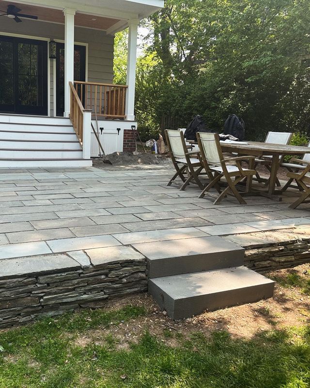 A patio with a table and chairs in front of a house.