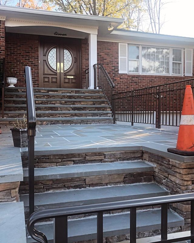 A brick house with stairs leading up to the front door