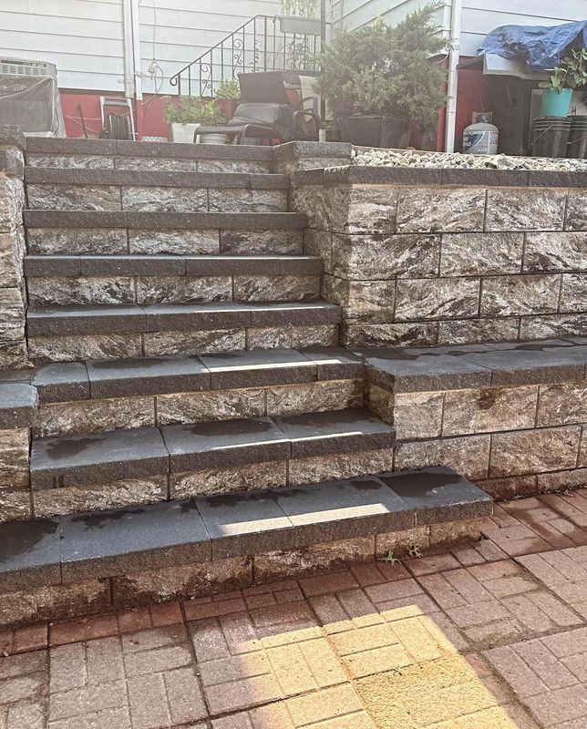 A set of stairs leading up to a brick wall.