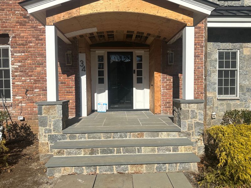 A brick house with a stone porch and steps