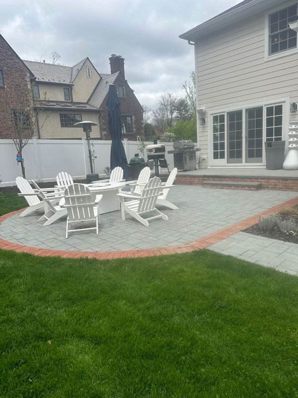 A patio with a table and chairs in front of a house.