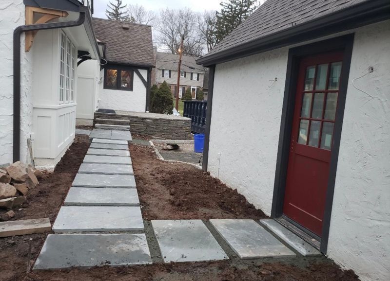 A white house with a red door and a walkway