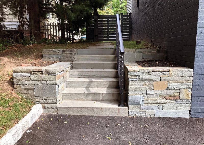 A set of stairs leading up to a stone wall.