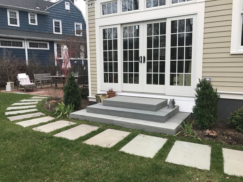 A house with a patio and stairs in front of it.
