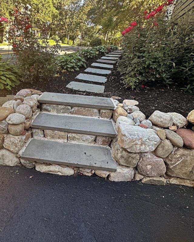 A stone walkway with steps leading up to a house.