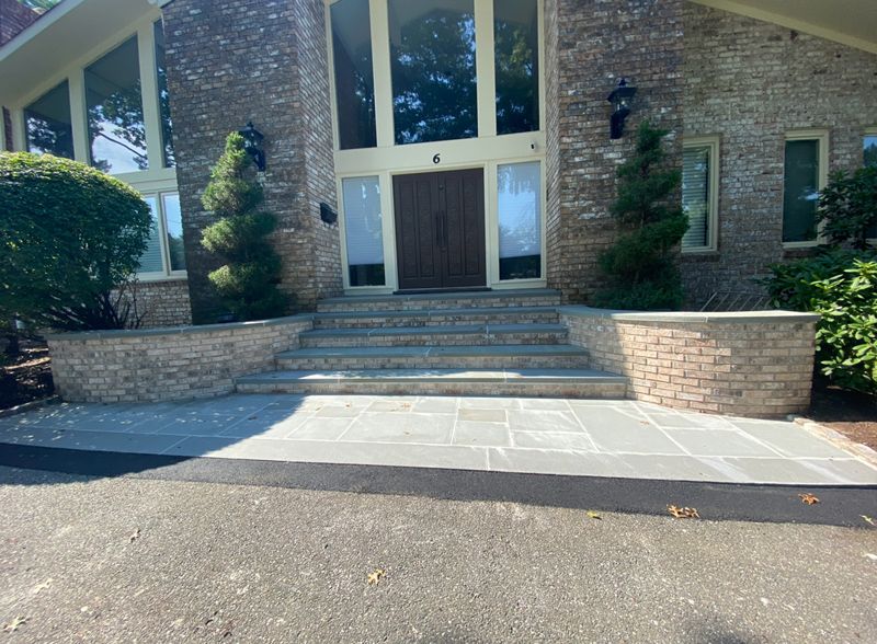 A large brick house with stairs leading up to the front door.