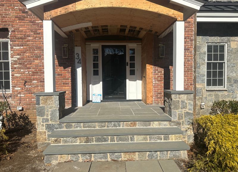 A brick house with a stone porch and steps