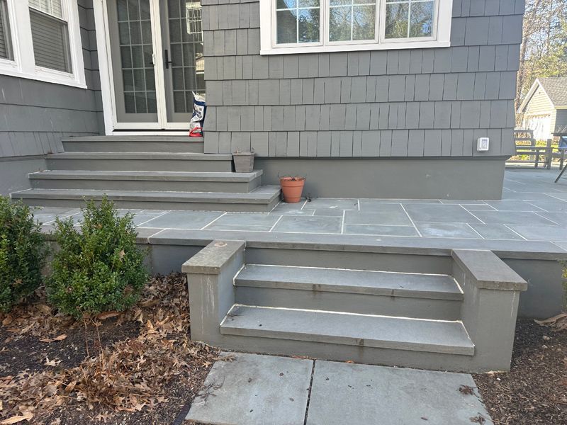 A house with stairs leading up to the front door.