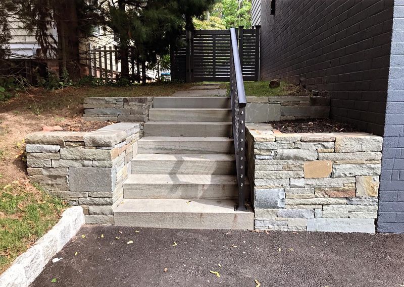 A set of stairs leading up to a stone wall.