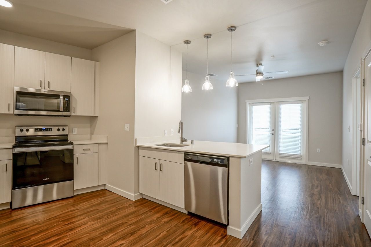 Open-concept kitchen with an island, white cabinets, and stainless-steel appliances.