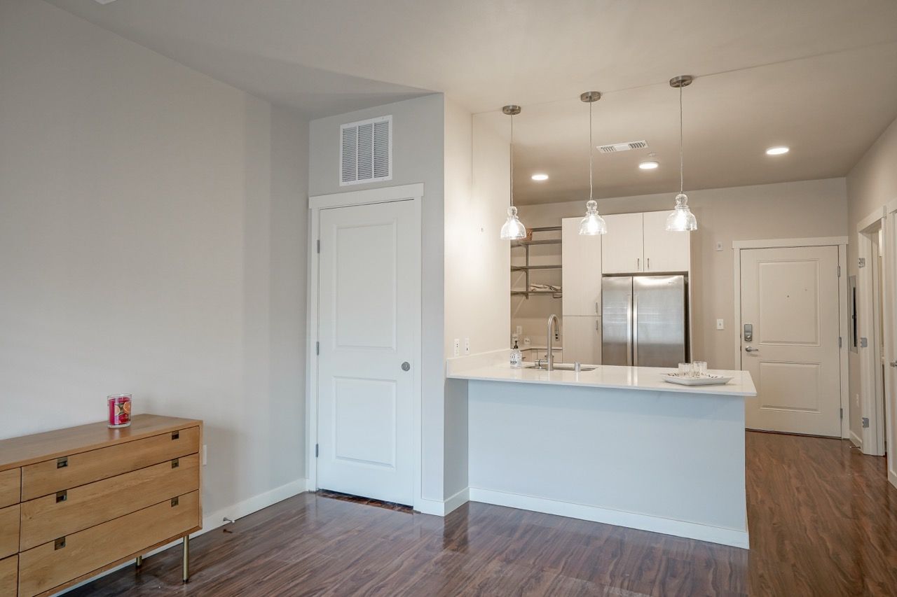 Open-concept kitchen with an island, pendant lights, and stainless steel appliances.