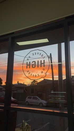 A Sunset is Reflected in the Window of a Restaurant — Coffee on High in Wauchope, NSW