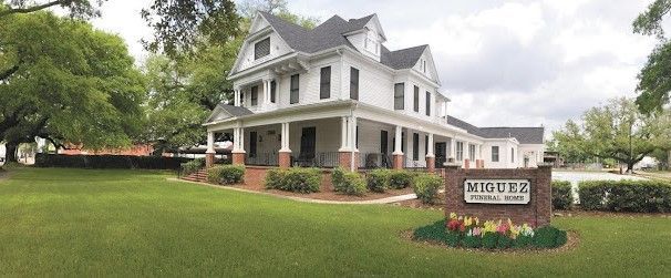 a building with hanging baskets of flowers in front of it .